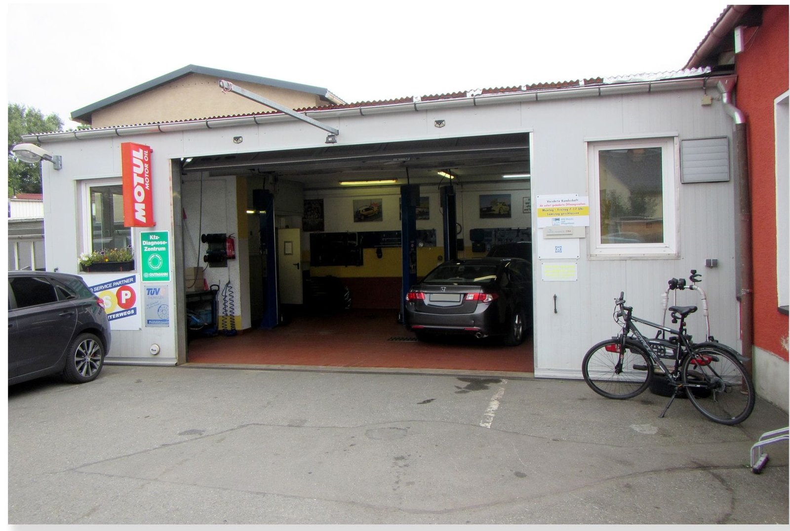 Offene Werkstatthalle des Autoservice Pitz in Schleiz mit Fahrzeug auf der Hebebühne